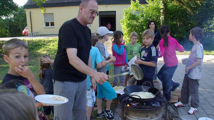 Tom Stöth frittiert "Chipsies" (Kartoffelspalten) mit den Kindern.