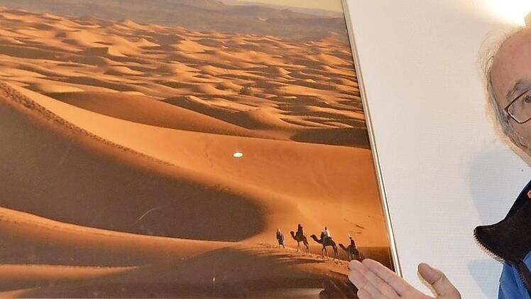 Peter Rex vor einem Foto der marokkanischen Wüste. 33 Aufnahmen seiner Reisen werden ausgestellt.  Foto: Bernhard Panzer
