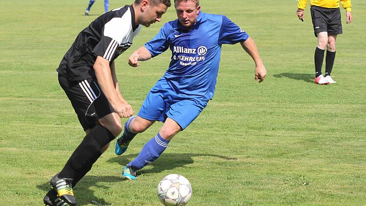 Der normalerweise für Prappach spielende Michael Kraft im Trikot des FC Augsfeld (rechts) kommt einen Tick zu spät. Sands André Schmitt kann an ihm vorbeiziehen.