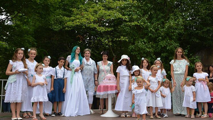 Zum großen Finale der Modenschau kamen die Models ganz in Weiß auf die Bühne. In der Mitte Margarete Bömmel (7. von links), die die Kleider entworfen und genäht hat. Foto: Björn Hein