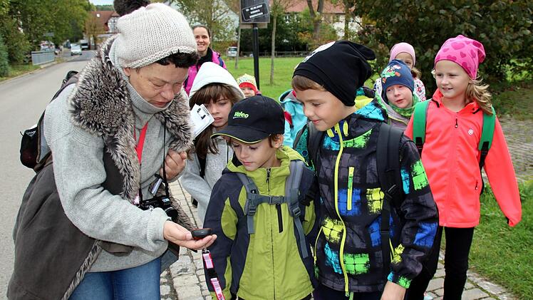 Eine Geocaching-Tour auf Martin Luthers Spuren bietet jetzt die Initiative Rodachtal in Heldburg an. Am Donnerstag konnten Schüler der Grundschule Hellingen sie erstmals testen. Auf dem Weg zum Startpunkt erläutert Martina Rohner (links) den Schülern das GPS-Ortungsgerät. Foto: Bettina Knauth