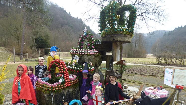 Die verkleideten Kinder v.l. Hannah Wolf, Daria Wolf, Mario Wrede, Noah Winkler, Eva Meinl, Leni Kuhn, Emil Kuhn und Marlen Wrede vor ihrem Märchen-Osterbrunnen Thomas Weichert