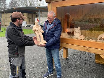 Andreas Schlembach (links) hat von Manfred Pretscher eine Krippe mit neun Figuren für die Kleinwenkheimer schnitzen lassen. Hier nimmt er den Josef aus den Händen des Hobby-Künstlers entgegen. Foto: Thomas Malz