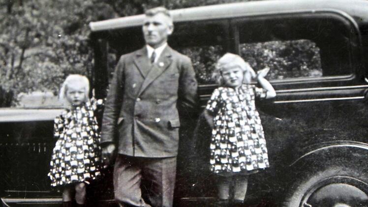 Die vierjährigen Zwillinge Resi und Rita (rechts) 1934 mit ihrem Vater Gustav vor seiner schwarzen Limousine, dem ersten Auto in Breitbrunn