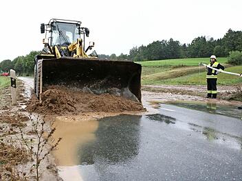 Die Staatsstraße 2203 bei Mistelfeld war nach dem gestrigen starken Regen überflutet. Im Bild sind die Bemühungen zu sehen, den abgerutschten Schlamm von der Fahrbahn zu bekommen. Fotos: Stefan Johannes
