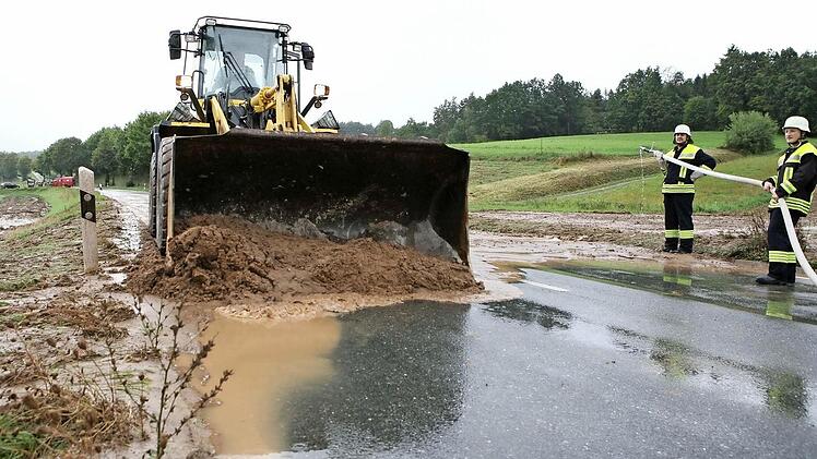 Die Staatsstraße 2203 bei Mistelfeld war nach dem gestrigen starken Regen überflutet. Im Bild sind die Bemühungen zu sehen, den abgerutschten Schlamm von der Fahrbahn zu bekommen. Fotos: Stefan Johannes