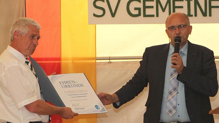Der Kreisvorsitzende des Bayerischen Fußballverbands, Gottfried Bindrim (rechts) überreichte Vorsitzendem Reinhold Klein zum Jubiläum die Ehrenurkunde des BFV. Foto: Günther Geiling