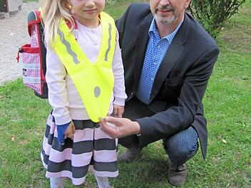 Der Vorsitzende der Kreisverkehrswacht Coburg Udo Skrzypczak zeigt mit Hilfe seiner Nichte Katharina Latychev den Gebrauch des signalgelben Überwurfs. Er wird wie ein Pallium über der normalen Bekleidung getragen.  Foto: Martin Koch