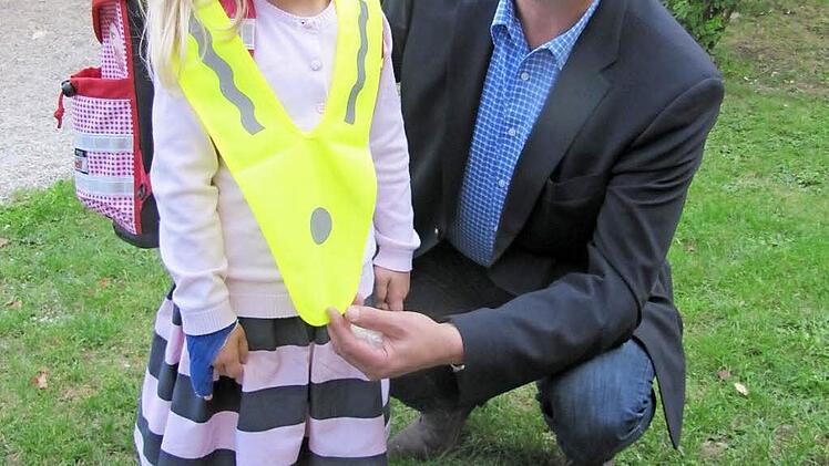 Der Vorsitzende der Kreisverkehrswacht Coburg Udo Skrzypczak zeigt mit Hilfe seiner Nichte Katharina Latychev den Gebrauch des signalgelben Überwurfs. Er wird wie ein Pallium über der normalen Bekleidung getragen.  Foto: Martin Koch