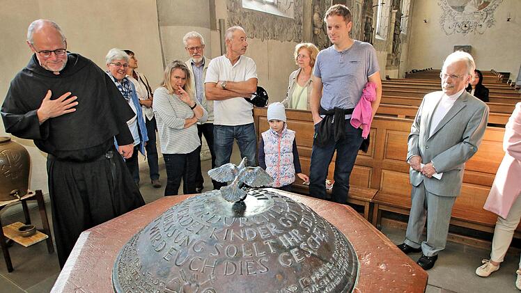 Zu einer Kirchenführung der besonderen Art hatte Pater Markus Reis in die  Pfarrkirche Maria Magdalena eingeladen. Er zeigte verdeckte oder wenig  beachtete Werke. Auf unserem Bild stehen die Besucher gerade vor dem  Taufstein, der 1613 geschaffen wurde. Der Deckel allerdings, eine Spende  der Kolpingfamilie, stammt von 1988. Foto: Dieter Britz