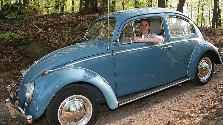 Der alte VW-Käfer, an dessen Steuer Miriam Drummer sitzt, glänzt, als wenn er gerade aus dem Laden gerollt wäre. Foto: Sylvia Hubele