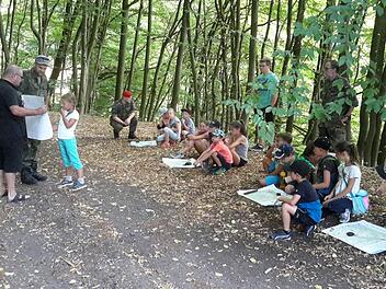 Die richtige Handhabung von Karte und Kompass vermittelten den Kindern Karl Veit von der Reservistenkameradschaft und Stefan Kießner von der Bundeswehr (beide links im Bild).  Foto: Rolf Pralle