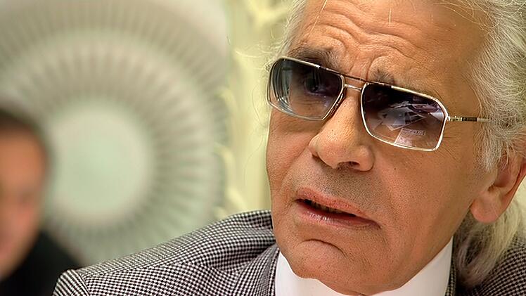 Karl Lagerfeld, mal nicht im schwarzen Outfit, aber mit der gerunzelten Stirn der Skepsis und der Ironie.