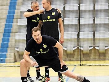 Während sich Torsteher Oliver Krechel gut gelaunt locker dehnt, legt Physiotherapeut Holger Stummer (im Hintergrund) auf der Schulter von Coburgs ersten Nationalspieler, Rechtsaußen Florian Billek, schon einmal Hand an. Fotos: Timo Geldner