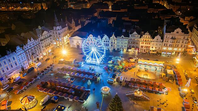 An aerial night shot of the Christmas markets in the square in Pilsen, featuring vibrant stalls surrounding the plaza and a large Ferris wheel lighting up the festive scene Eine Luftaufnahme der Weihnachtsm&auml;rkte auf dem Platz in Pilsen bei Nacht, mit lebhaften St&auml;nden rund um den Platz und einem gro&szlig;en Riesenrad, das die festliche Szene beleuchtet Weniger anzeigen  von Martin