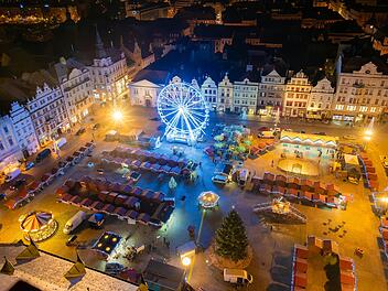 An aerial night shot of the Christmas markets in the square in Pilsen, featuring vibrant stalls surrounding the plaza and a large Ferris wheel lighting up the festive scene Eine Luftaufnahme der Weihnachtsmärkte auf dem Platz in Pilsen bei Nacht, mit lebhaften Ständen rund um den Platz und einem großen Riesenrad, das die festliche Szene beleuchtet Weniger anzeigen  von Martin