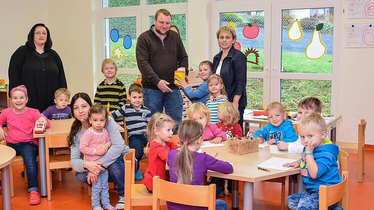Daniel Schlereth (Mitte) bekommt von Sohn Vincent die Spende in Höhe von 500 Euro überreicht. Rechts Kindergartenleiterin Edeltraud Arnold, links Kinderpflegerin Alexandra Leichmann und vorne Ramona Hein vom Elternbeirat.  Foto: Björn Hein
