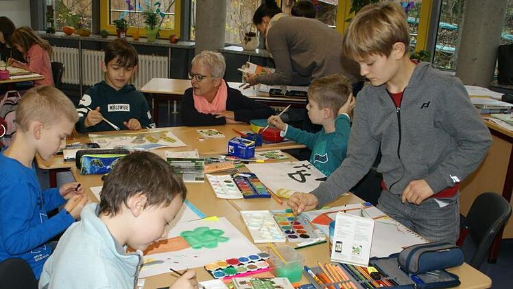 Mit Feuereifer waren die Oberauracher Grundschüler dabei, am Bilderbuch des Umweltbildungszentrums mitzuwirken. UBIZ-Leiterin Bettina Stroh (hinten am Tisch rechts) lieferte fachliche Details für die Malereien.Sabine Weinbeer