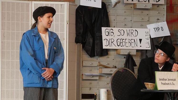 Bettler Finch (Sophia de Clerk) bewirbt sich beim Geschäftsmann Peachum (Ida Söldner) um eine Bettellizenz.