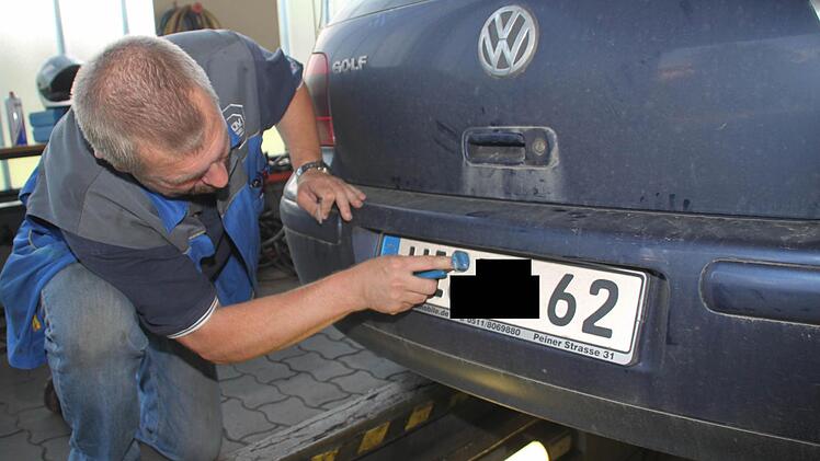 Nach einer halben Stunden hat der Golf den Sicherheitscheck geschafft. Günter Teufel kratzt die alte TÜV-Plakette ab ...
