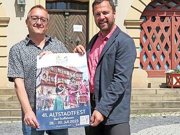 Markus Alin und Bürgermeister Mario Schönwald (rechts) stellen das offizielle Programm für das Altstadtfest in Bad Staffelstein vor.