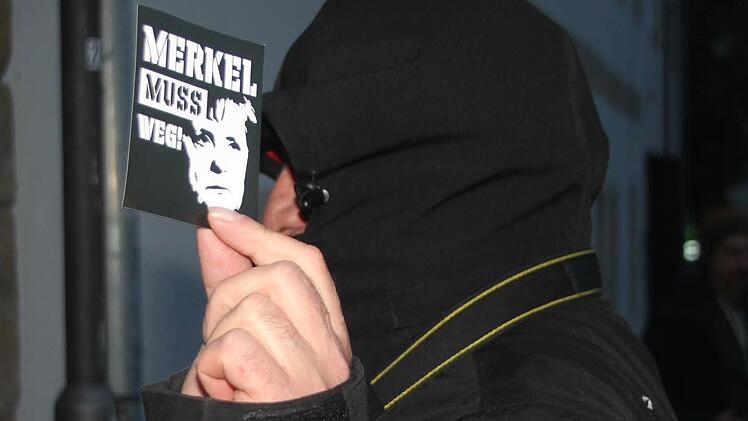 Vermummter AfD-Fotograf, der seinen Merkel-muss-weg-Aufkleber nicht hergeben wollte und sich Spott und Gelächter gefallen lassen musste: "Haste keine Eier?" Foto: Stephan Tiroch
