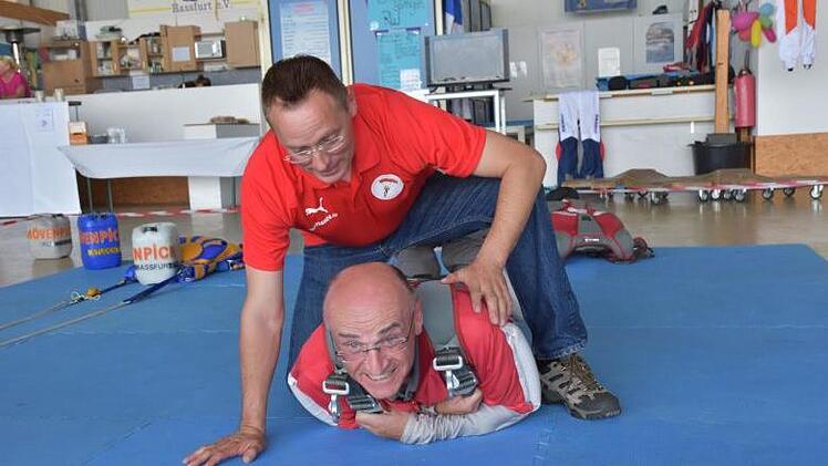 Landrat Wilhelm Schneider (unten) musste vor seinem Sprung Trockenübungen mit dem Tandempiloten Dirk Rentzsch machen. Foto: Christian Licha