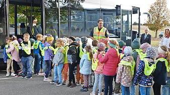 Die ABC-Sch&uuml;tzen &uuml;ben das sichere Verhalten an der Haltestelle und im Bus, im Hintergrund Polizeioberkommissar Matthias Kleren, Roland Friedrich und Tanja Erdmann.