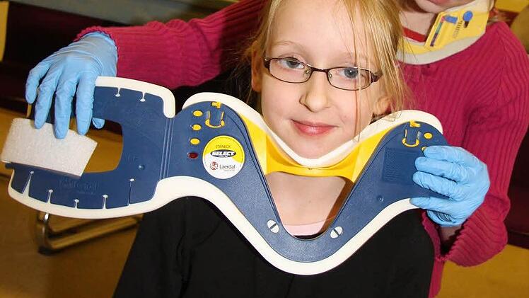 Michelle Bergeron (12) legt Leonie Tulke (10) eine Kopfstütze an.