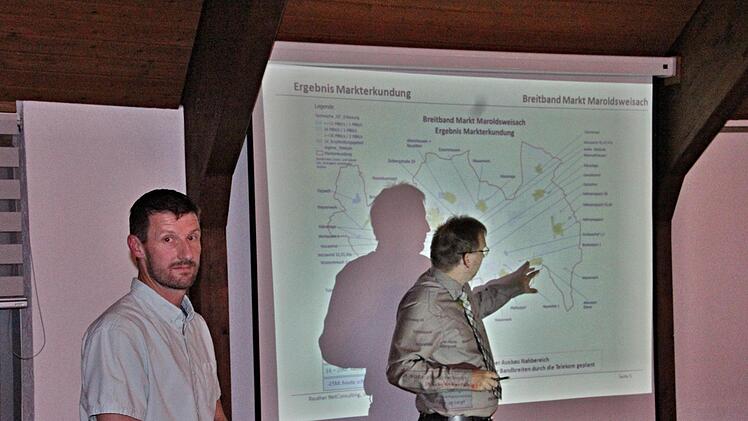 Telekommunikationstechniker Enrico Meierhof von der Firma Reuther NetConsulting aus Bad Staffelstein (links), gab dem Gemeinderat umfangreiche Informationen zum schnellen Internet. "Schattenmann" Bürgermeister Wolfram Thein (rechts) erläuterte anhand einer Karte genauere Details. Foto: Helmut Will