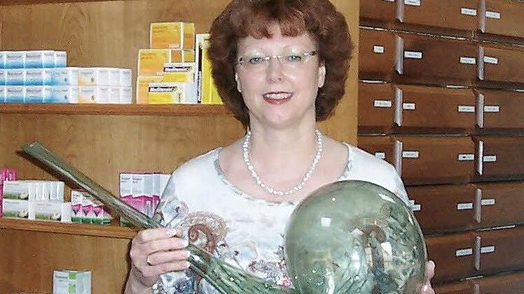 Inhaberin Renate Stichl-Gürk mit einem der Gläser aus 18. Jahrhundert. Sie hat eine bemerkenswerte Sammlung antiker Apothekeninstrumente.