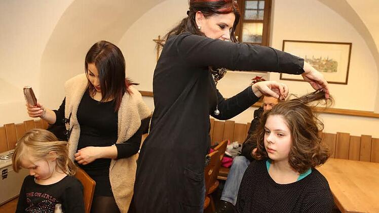 Ebru Kaya (l.) und Ingrid Langmar von Friseur Weber zaubern den Mädchen Engelslocken in die Haare. Foto: Barbara Herbst