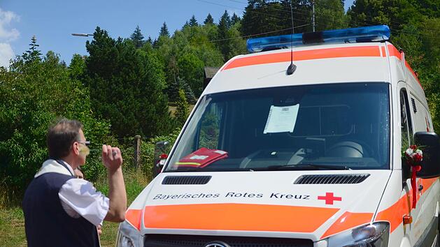 Mit Weihwasser stellt Pfarrer Richard Reis das Katastrophenfahrzeug der BRK Bereitschaft Steinwiesen unter den Schutz Gottes. Florian Wei&szlig;