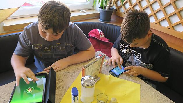 Voll konzentriert sind Constantin (l.) und sein Kumpel Andr&eacute; bei der Jagd nach Pok&eacute;mon. Foto: J. Blum