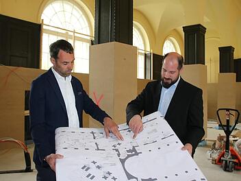 Architekt Roland Breunig (von links) und Timo Tully, Leiter des Gästeservices bei der Staatsbad GmbH, stimmen Details auf dem Plan ab. Im Hintergrund der zum Schutz der Täfelung verkleidete Saal. Fotos: Ralf Ruppert