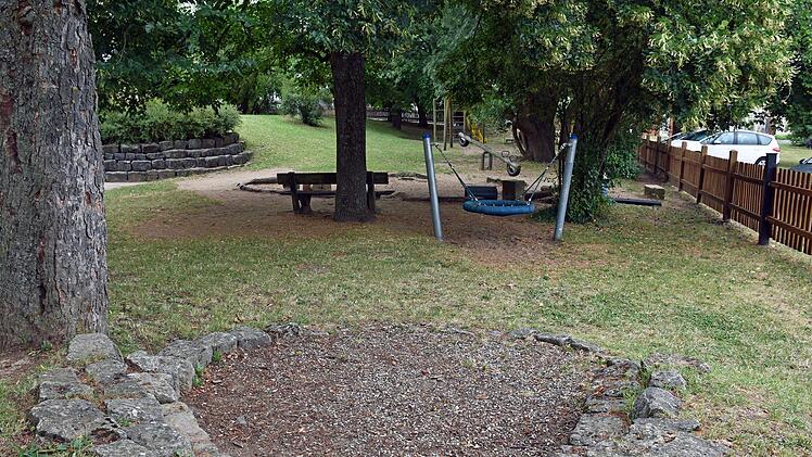 Im Garten des Kindergartens Untertheres soll unter anderem der Platz am Sitzbereich (im Vordergrund) gepflastert und dort einen Wasserspielbereich angelegt werden. Dem sollen sich ein neuer Sandkastenbereich mit einer kleinen Spielhütte, ein Klettertrum mit Rutsche sowie Holz- und Netzbrücke, weitere Holzstämme zum Klettern anschließen.Ulrike Langer