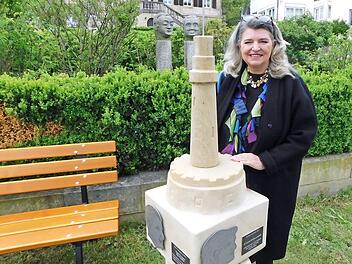 Laura Krainz-Leupoldt im Skulpturengarten vor dem Sandsteinwürfel im Skulpturengarten, auf dem ihr Konterfei jetzt verewigt ist.
