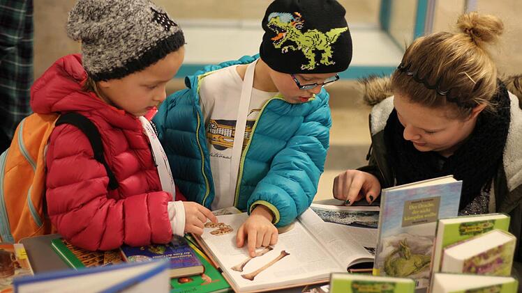 Die Zwillinge Sophie (6/links) und Moritz (6/Mitte) waren die jüngsten Studenten der Kinder-Uni in der Kronacher Lucas-Cranach-Grundschule. Sie wollten mehr wissen und ließen sich daher von einer Helferin aus den Schulbüchern vorlesen. Foto: Mariell Dörrschmidt