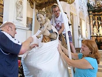 Otmar Deuber (l.), Christoph Kemmer und Roswitha Deuber legen Hand an beim Einkleiden des Gnadenbildes.   Fotos: Marion Krüger-Hundrup
