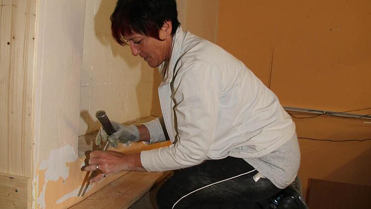 Selbst ist die Frau: Doris Hörteis beseitigt mit dem Stemmeisen die hölzerne Verkleidung.