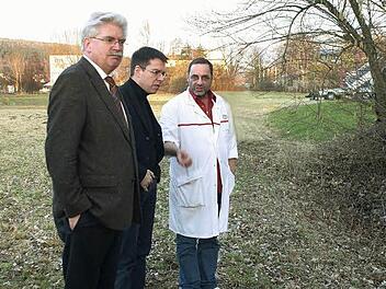 Der Schein trügt: Die trockene Wiese verwandelt sich nach starken Regenfällen in einen See. Dann läuft das Wasser auch in das Firmengebäude von Metzger Thomas Weiß (rechts). Ein Bild der Verhältnisse machten sich gestern der Generalsekretär der bayerischen FDP, Bundestagsabgeordneter Martin Zeil (links) und der Stadt- und Kreisvorsitzende der Kulmbacher FDP, Thomas Nagel. Foto: Gabriele Hänseler
