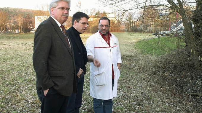 Der Schein trügt: Die trockene Wiese verwandelt sich nach starken Regenfällen in einen See. Dann läuft das Wasser auch in das Firmengebäude von Metzger Thomas Weiß (rechts). Ein Bild der Verhältnisse machten sich gestern der Generalsekretär der bayerischen FDP, Bundestagsabgeordneter Martin Zeil (links) und der Stadt- und Kreisvorsitzende der Kulmbacher FDP, Thomas Nagel. Foto: Gabriele Hänseler