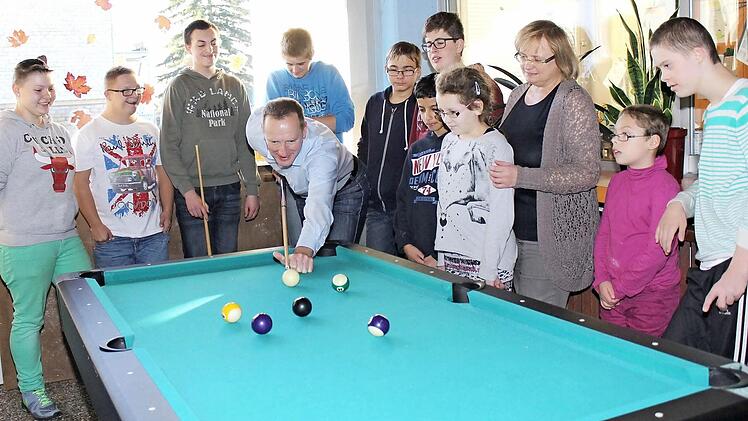 Konzentriert fixiert Eltmanns Bürgermeister Michael Ziegler die Kugel an, beobachtet von einigen Kindern und Jugendlichen der Tagesstätte sowie Leiterin Isolde Martin (Dritter von rechts). Julian (Dritter von links) hatte bei der Partie gegen den stellvertretenden Landrat viel Spaß.  Foto: rn