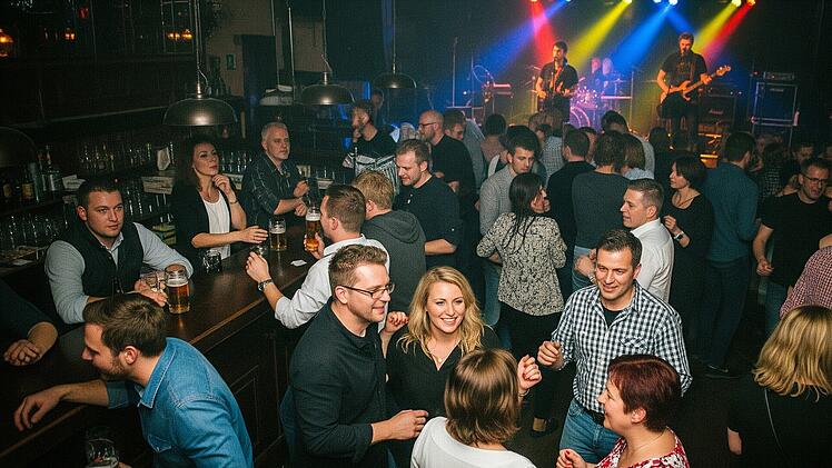 Livekonzert in einer Musikkneipe mit Tresen. Gemischtes Publikum.