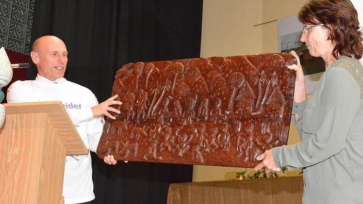 Eine Holzschnitzerei mit dem Hl. Abendmahl aus Papua Neuguinea überreichte Pfarrer Stephan Aupperle und seine Frau Sabine den Ermershäusern. Foto: Schmidt