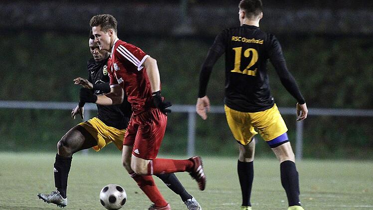 Der Hallstadter Michael Pfänder (rotes Trikot) behauptet sich gegen Kingsley Osuji (hinten) und Thomas Reuß vom RSC Oberhaid. Fotos: sportpress