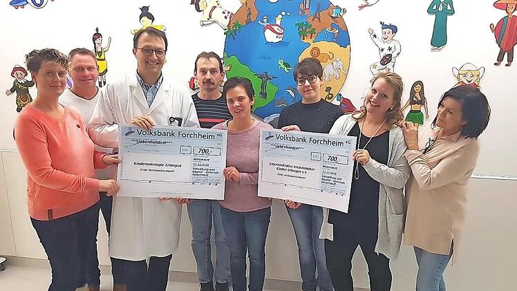 Die Gemeindeangestellten und Simone Schad übergeben die Spenden an Vertreter der Elterninitiative krebskranker Kinder Erlangen und die Kinderonkologie Erlangen. Foto: Mathias Erlwein