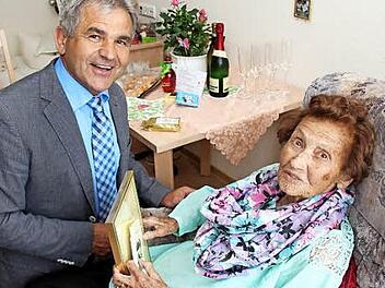 Bürgermeister Ludwig Nagel ging sogar in die Knie, um Elfriede Hoffmann die Geschenke der Gemeinde zu überreichen. Foto: Johanna Blum
