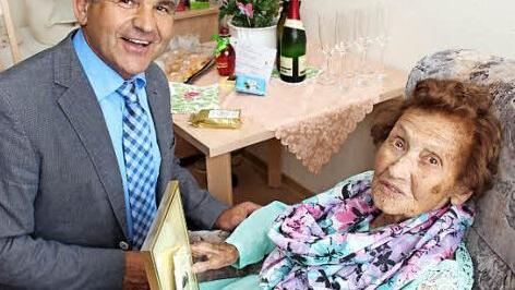 Bürgermeister Ludwig Nagel ging sogar in die Knie, um Elfriede Hoffmann die Geschenke der Gemeinde zu überreichen. Foto: Johanna Blum