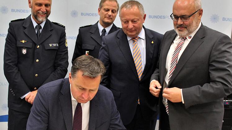 Staatssekretär Stephan Mayer trägt sich ins goldene Buch der Gemeinde Oerlenbach ein, dahinter (von links) Polizeipräsident Alfons Aigner, Polizeidirektor Ralf Wiegand, Landrat Thomas Bold und Bürgermeister Franz Kuhn. Foto: Werner Vogel